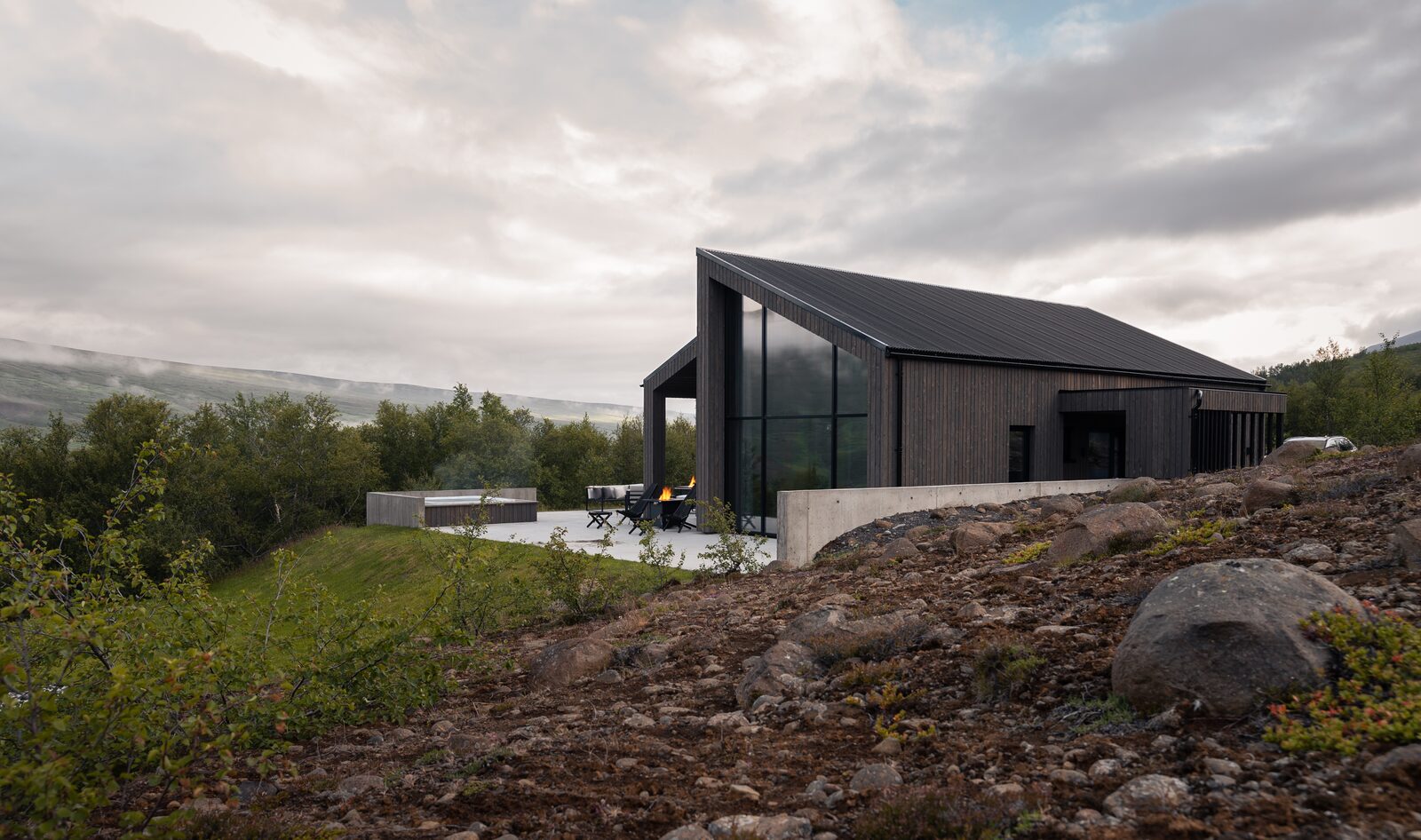 The house at Lundskógur and its terrace at dusk beneath a blue-grey sky.
