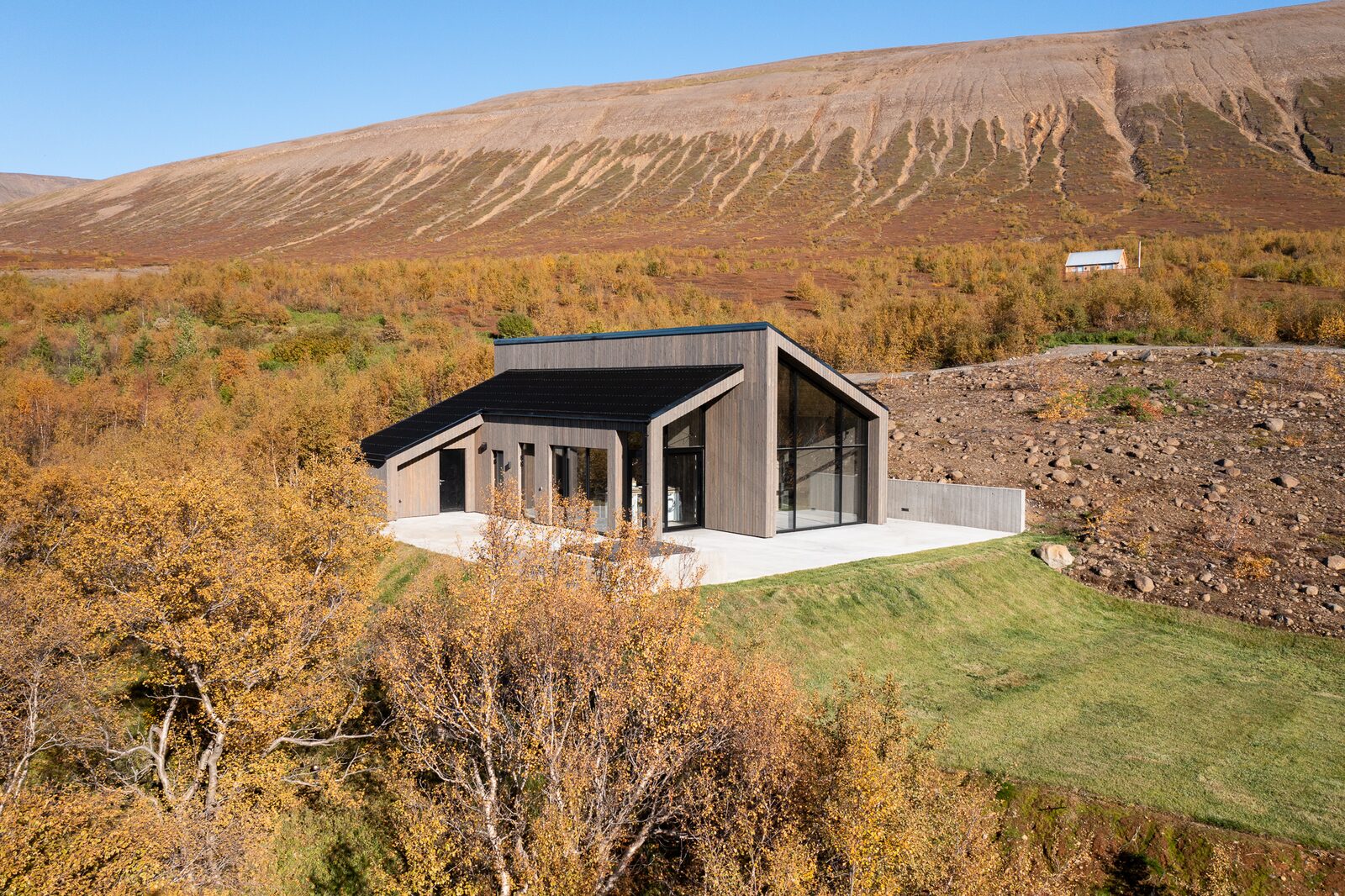 An aerial view of the house at Lundskógur against the broad autumn landscape of Fnjóskadalur.