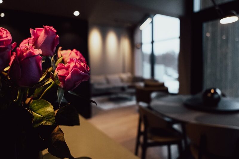 The dining table set with cutlery and red roses.
