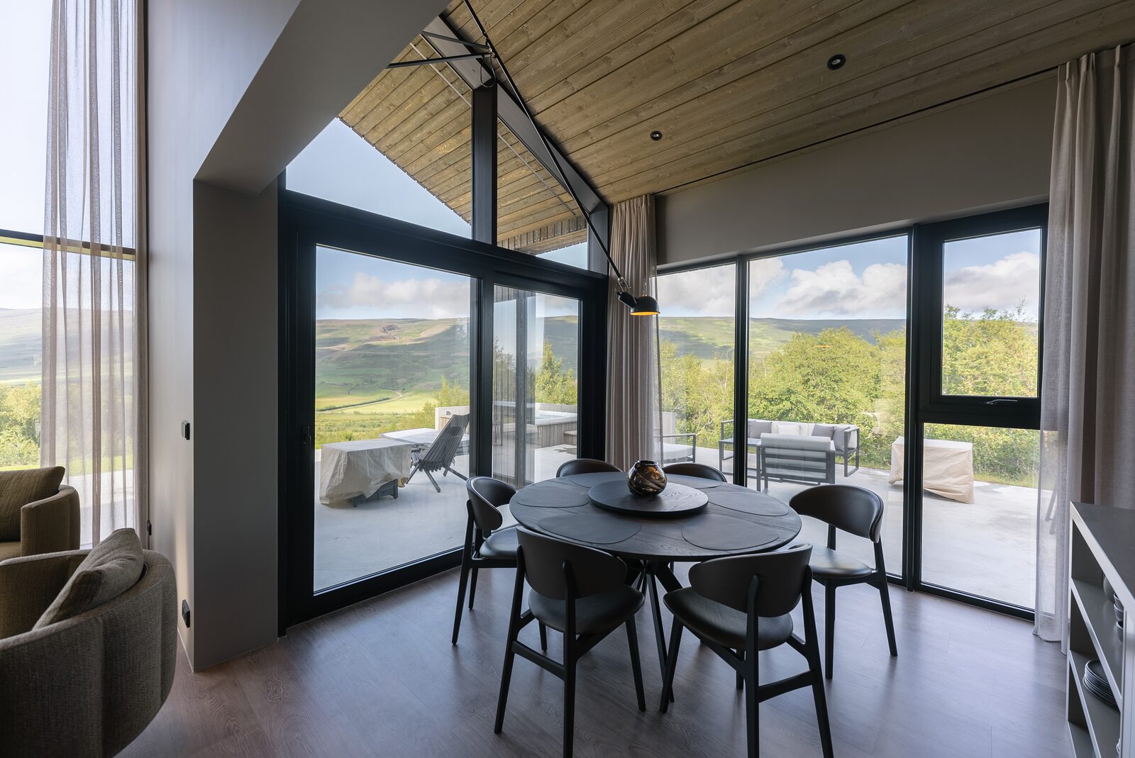 The dining table beside a full-height window overlooking the valley.