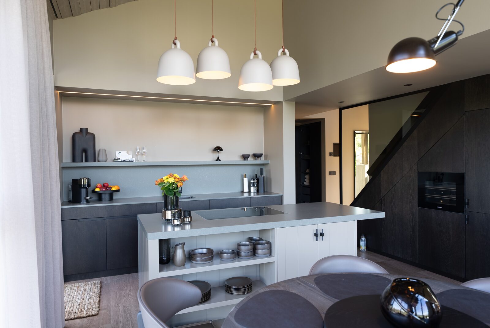The kitchen island beneath pendant lights, with the living area beyond.