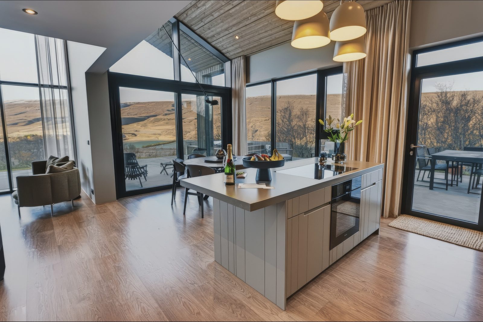 The kitchen island and a glass door to the terrace, with the hills of the valley through the windows.
