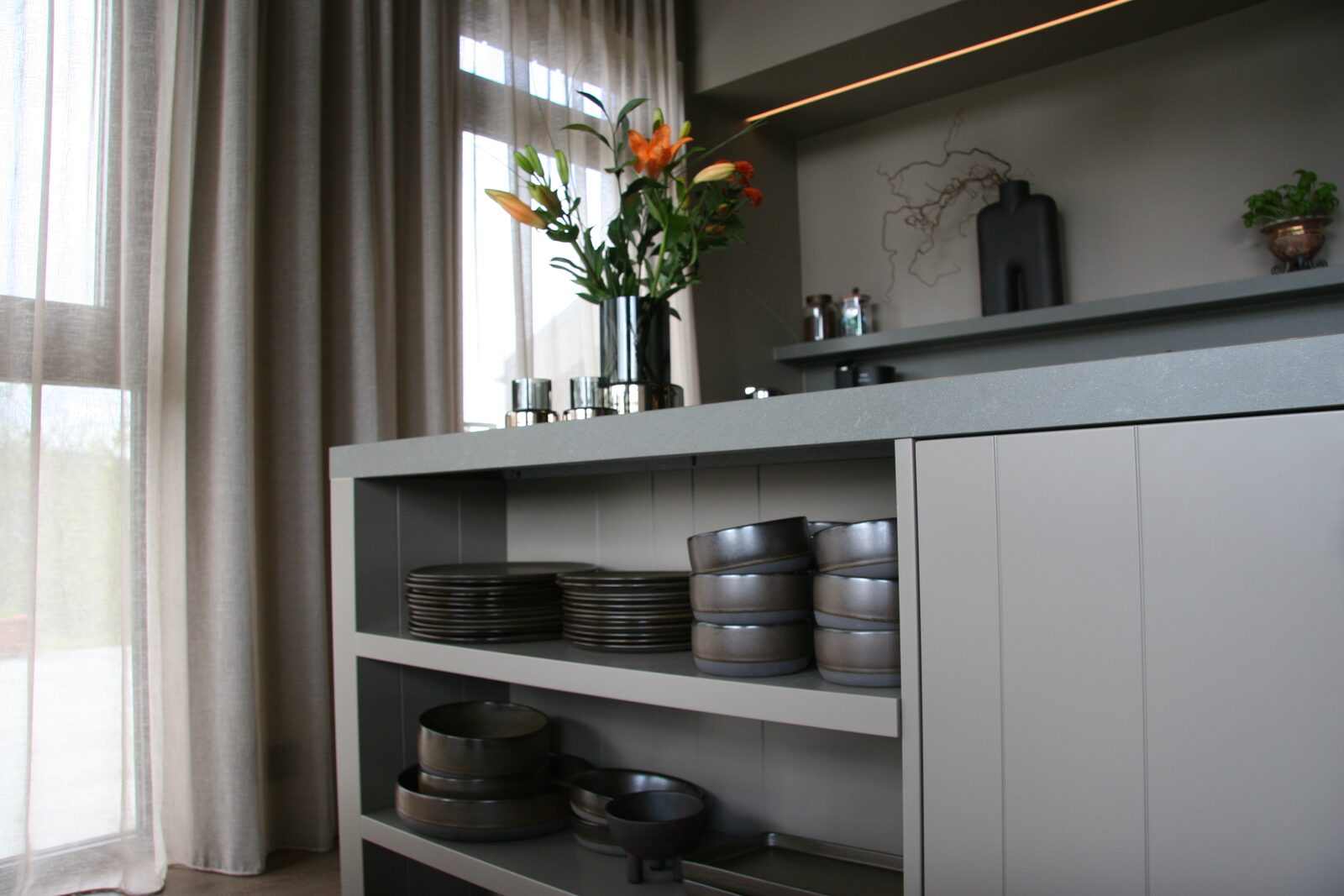 Open kitchen shelving with stacked crockery and bowls.