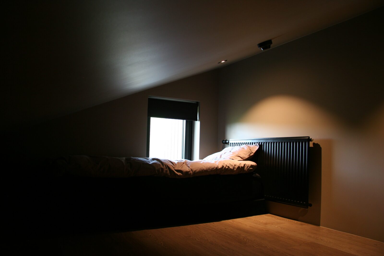 A single bed beneath the window in the upstairs side room.
